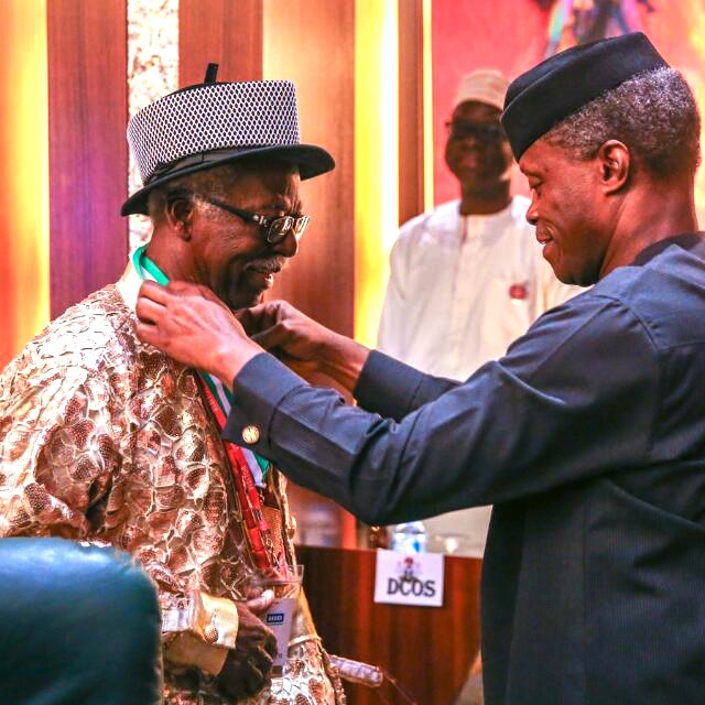 Dr Bruce Onobrakpeya being decorated with NNOM by Vice President, Yemi Osinbajo